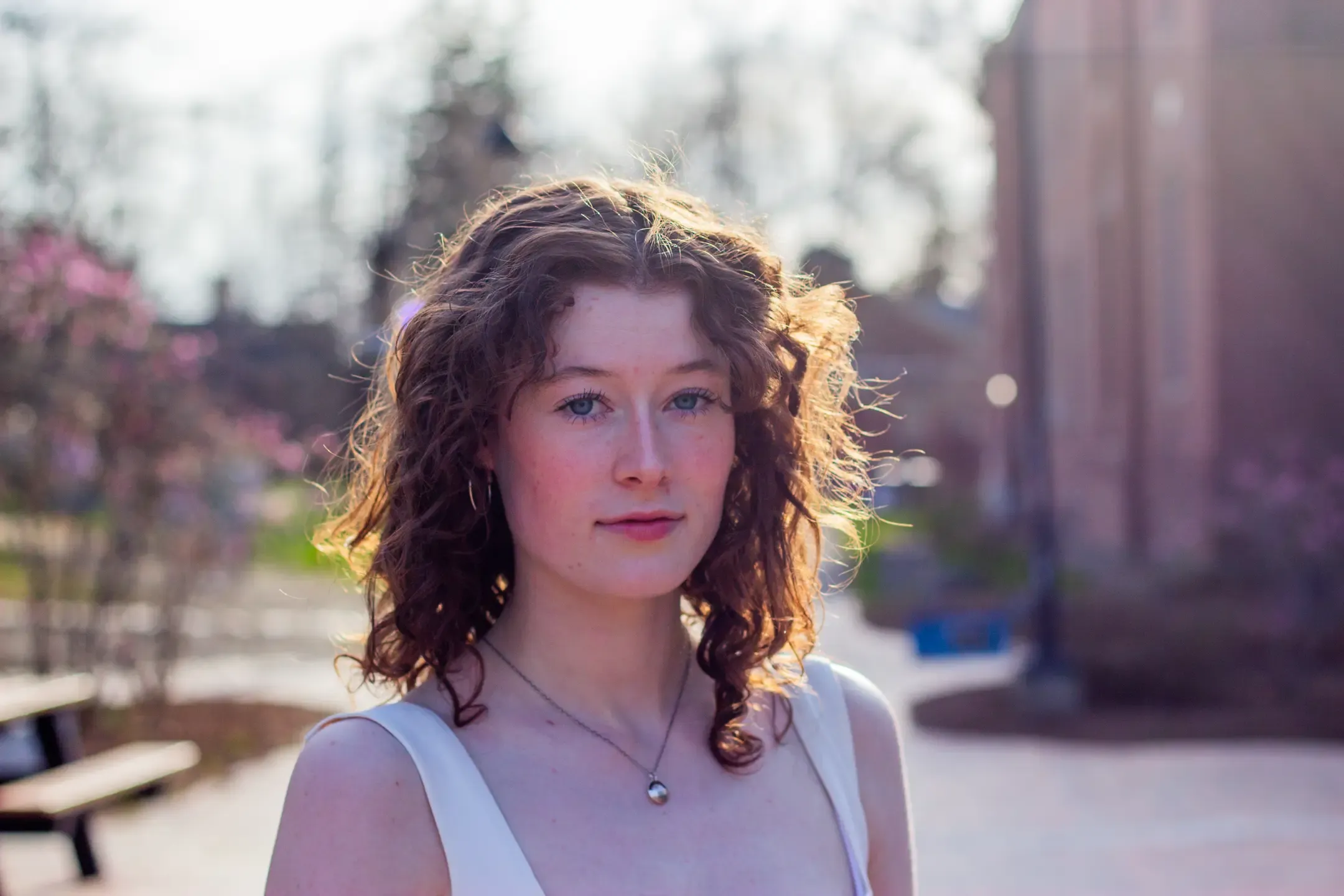 Title: Halo, Description: Portraite of a young woman with a halo of light in her hair and pink flowers in the background