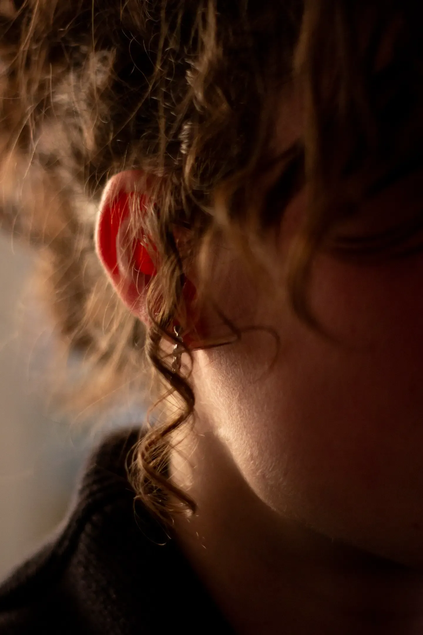 Title: Intimate, Description: A close up photo of a lock of hair over a woman's ear