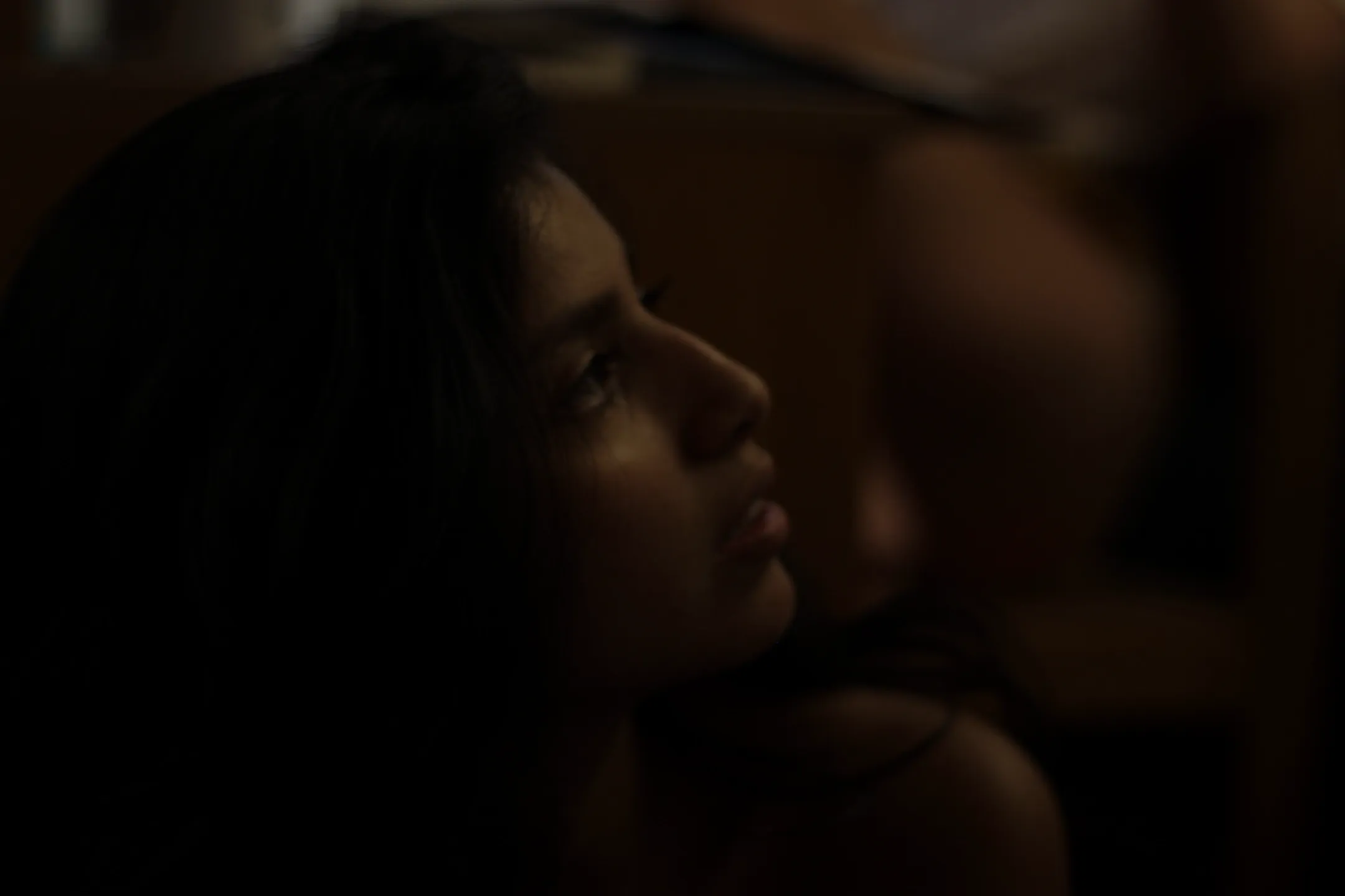 Title: Mood, Description: A young woman looking off screen in a dimly lit room